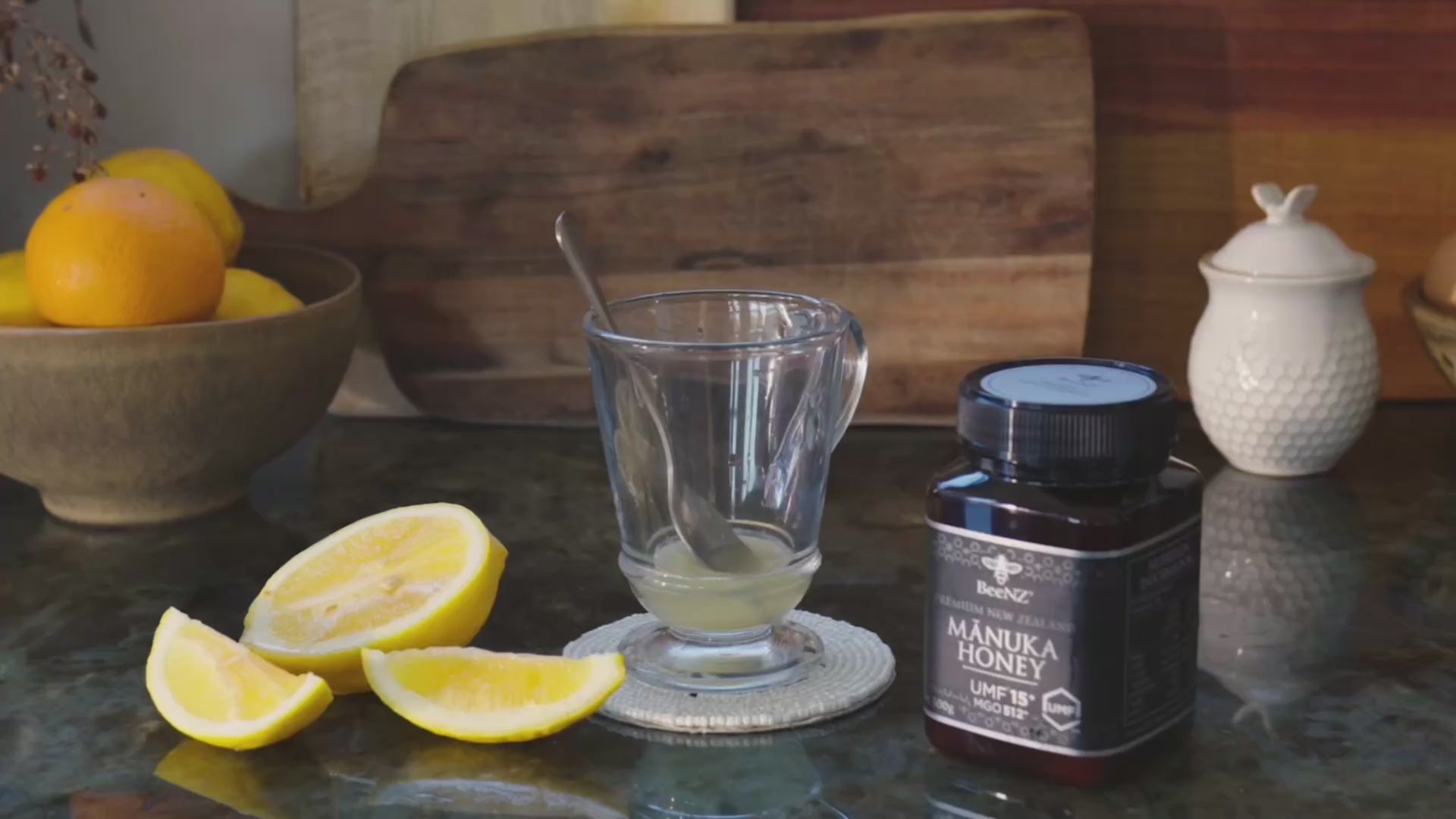 Video showing BeeNZ manuka honey umf15+ with a glass of lemon juice, then adding honey and hot water to the glass to make a hot lemon honey drink. 