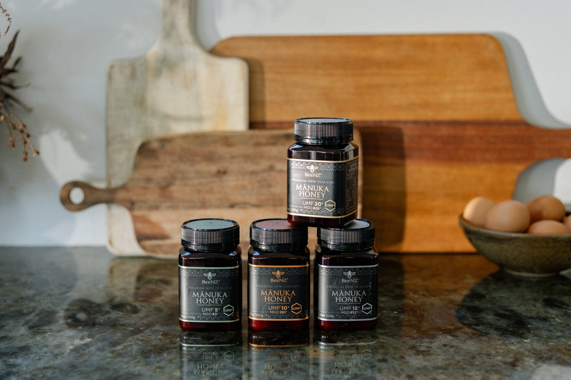 Jars of BeeNZ manuka honey sitting on a bench
